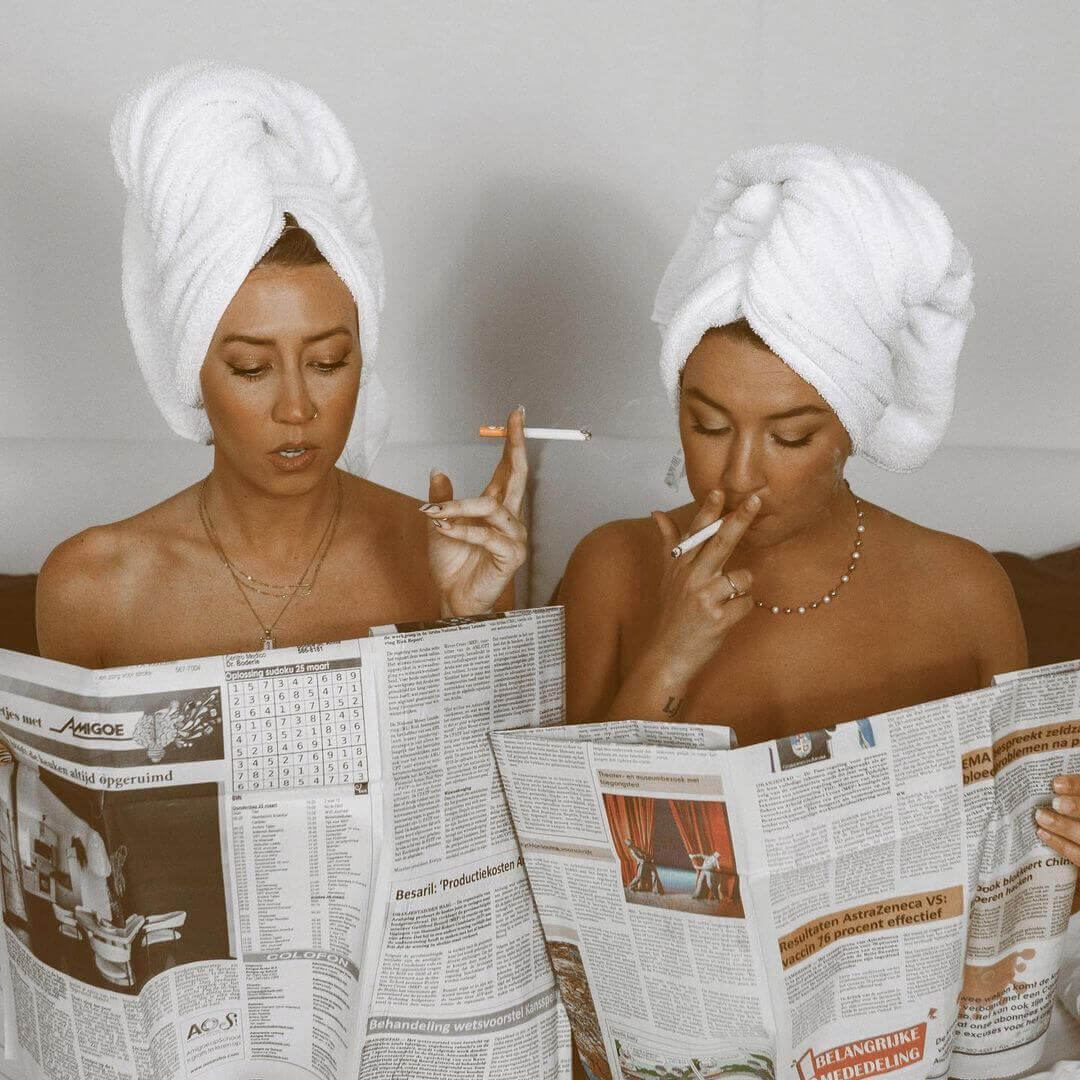 women reading newspapers two women reading newspapers while smoking mountain smokes hemp cbd smokes